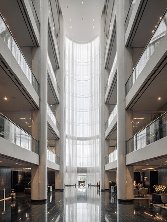 Interior of a modern office building with glass walls and large windowsの素材
