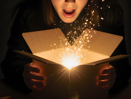 Young woman opening magic book with sparkler on dark background, closeupの素材