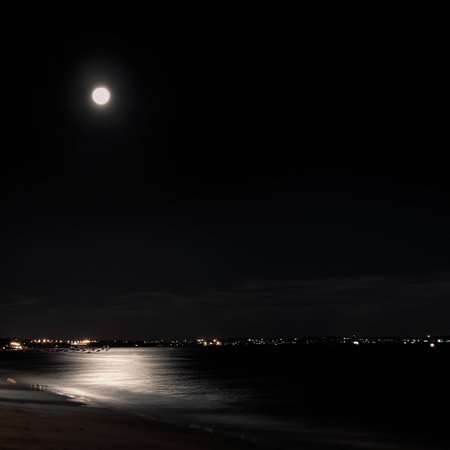 Beautiful view of a city at night with a moon shining on it.の写真素材