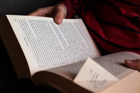 Reading a dog earred paperback bookの写真素材