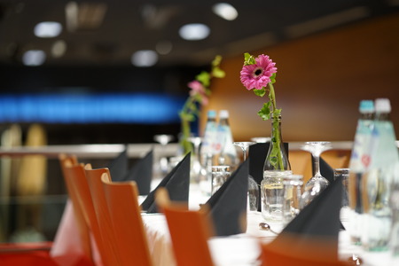 Table set on a gala dinner with a flower in the middle
