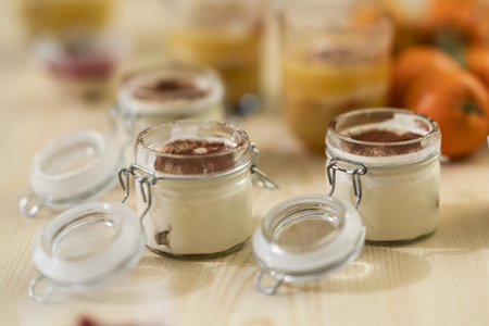 sweet and tasty deserts tiramisu, made out of coffee and mascarpone in a closeable glass on a tableの写真素材