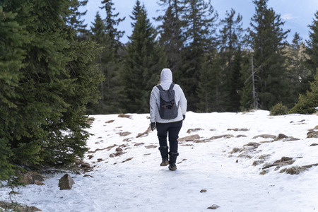 Women hiking with a backpackt hrough snow on a snowy hiking path in south tyrol italyの写真素材