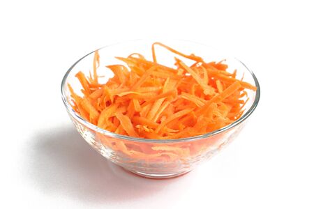 Grated carrots in a bowl on a white backgroundの写真素材