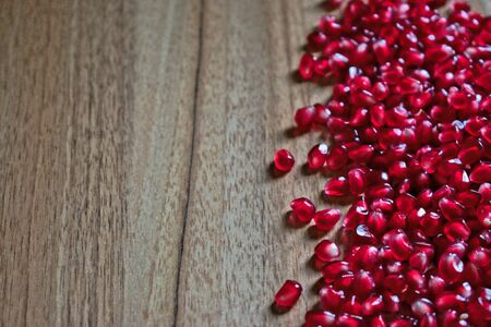 Pomegranate seeds on a wooden tableの写真素材