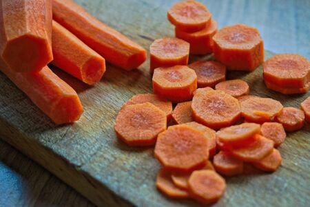 Whole and chopped carrots on a cutting boardの写真素材