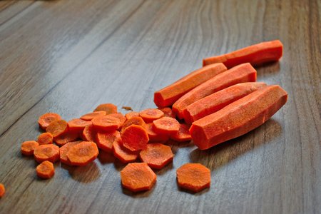 Chopped and whole carrots on a wooden tableの写真素材