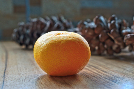 Tangerine and pine cones on a wooden tableの写真素材
