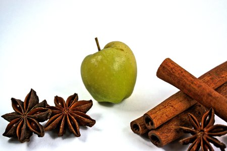 Tiny green apple with cinnamon sticks and star anise on a white backgroundの写真素材