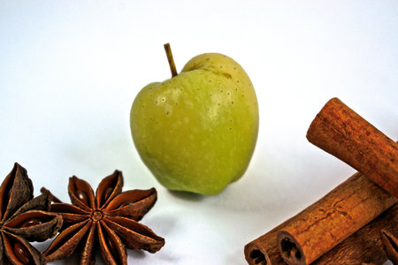 Tiny green apple with cinnamon sticks and star anise on a white backgroundの写真素材