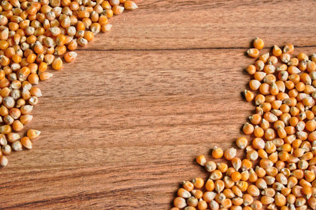 Popcorn kernels on a wooden tableの写真素材