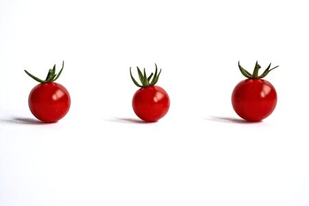 Closeup of ripe cherry tomatoes on a white backgroundの写真素材