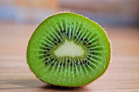 Closeup of a kiwi on a wooden tableの写真素材