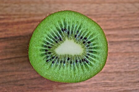 Closeup of a kiwi on a wooden tableの写真素材