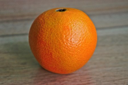 Closeup of an orange on a wooden tableの写真素材