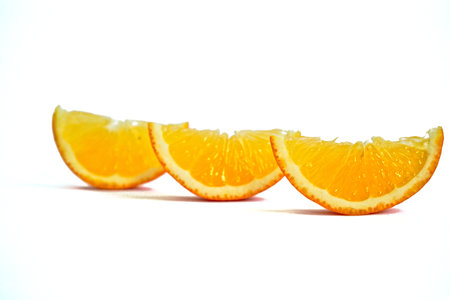 Closeup of orange wedges on a white backgroundの写真素材