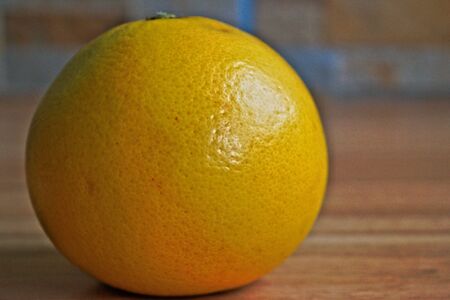 Closeup of a yellow grapefruit on a wooden tableの写真素材
