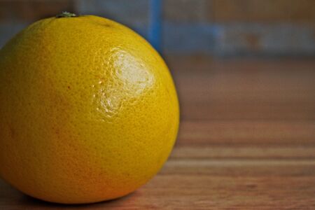 Closeup of a yellow grapefruit on a wooden tableの写真素材