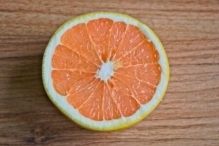 Closeup of a grapefruit half on a wooden tableの写真素材