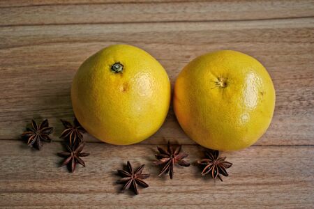 Two grapefruits and star anise on a wooden tableの写真素材