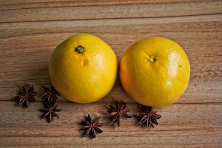 Two grapefruits and star anise on a wooden tableの写真素材
