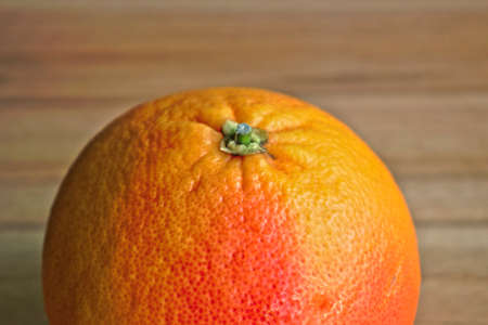 Closeup of a red grapefruit on a wooden tableの写真素材