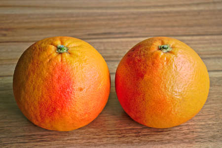Two red grapefruits on a wooden tableの写真素材