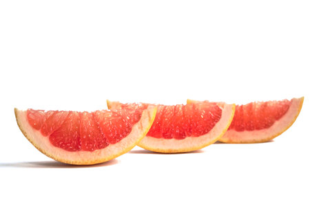 Closeup of grapefruit wedges on a white backgroundの写真素材
