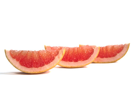 Closeup of grapefruit wedges on a white backgroundの写真素材