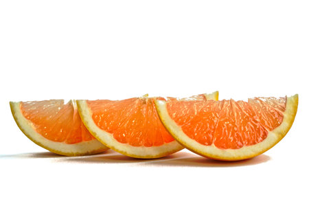 Closeup of grapefruit wedges on a white backgroundの写真素材