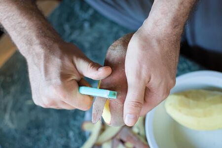 Closeup of hands peeling a potatoの写真素材