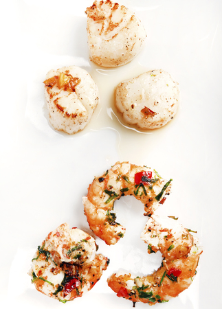 Scallops and shrimps on white backgroundの写真素材