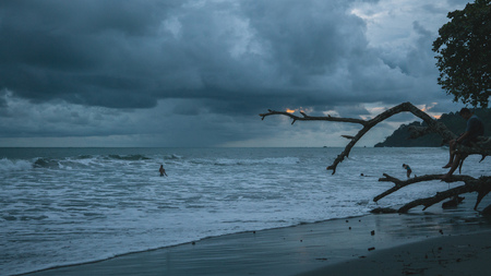 Dark beach at dusk with heavy cloudsの写真素材