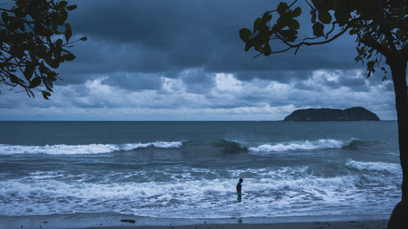 Dark beach at dusk with heavy cloudsの写真素材