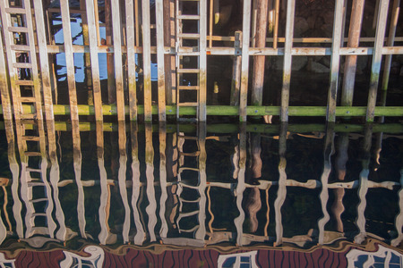 Abstract impression, reflective closeup of wooden houses built over the sea at Lofoten islands, Norwayの写真素材