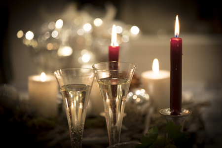 Festive new years eve candlelight scenery with glasses of sparkling champagneの写真素材