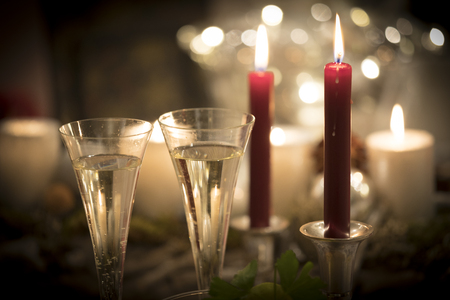 Festive new years eve candlelight scenery with glasses of sparkling champagneの写真素材
