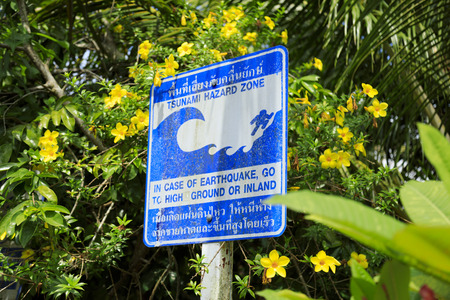 blue sign warning of a tsunami hazard zone taken on a road on a small island in southeast thailand, asiaの写真素材