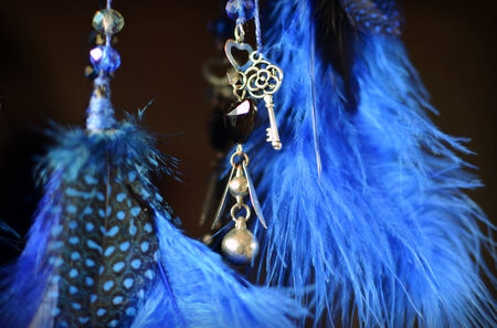 Blue dream catcher hanging on dark background close up with suspension key and heartの写真素材