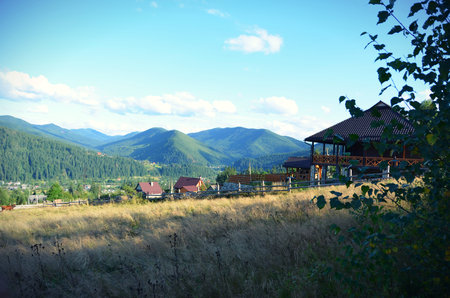 Stunning views of the village and the mountains before sunset with a house in the foregroundの写真素材