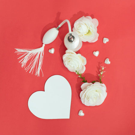 concept of white roses and perfume on a red background, creative concept for Valentine's Day and Mother's Dayの写真素材