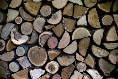 Natural wooden logs cut and stacked in pile, felled by the logging timber industry, Abstract photo of a pile of natural wooden logs backgroundの写真素材