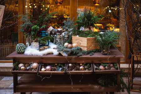 An open box with Christmas toys is on the round table. The table is laid out with white skin.のeditorial素材