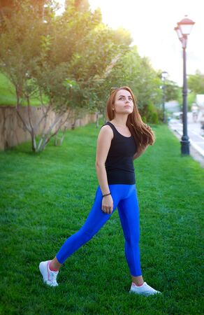 Fitness, sports, yoga in the open air, in the park. A young woman in nature is engaged in sports, yoga. Healthy lifestyle. Photo on the nature.の写真素材