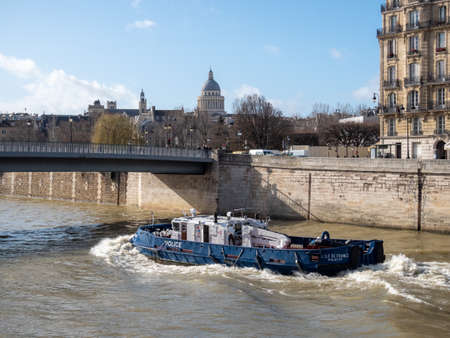 February 17, 2020. Paris, France. Police boat on the river Seine in Paris. Full speed ahead.のeditorial素材