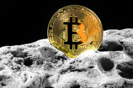 Golden Bitcoin Coin on grey rock . Bitcoin cryptocurrency. Business concept