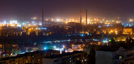 Panorama of the night city. Industrial area. Factory pipes without smokeの写真素材