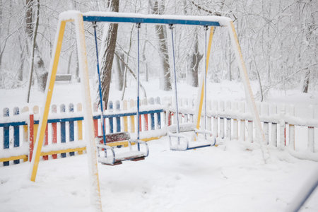 Snow-covered multi-colored fence made of wood. Severe frost, the playground is closed. Snowingの写真素材