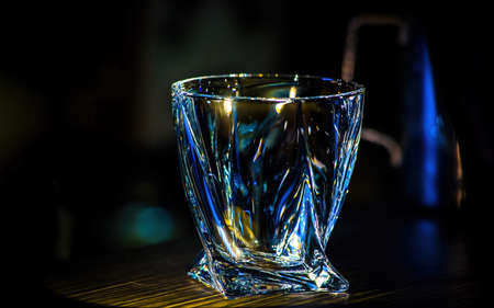 An empty glass beaker glows on a dark background.の写真素材