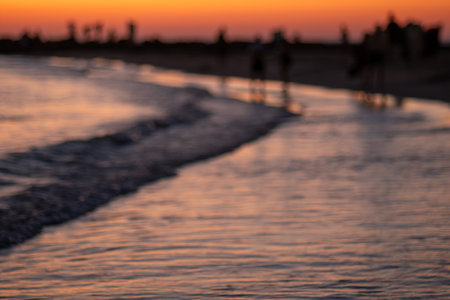 beach sunset concept. Abstract beach Beautiful blurred sunset sky. blurring seaside on twilight cloud, sunrise warm sunlight. Defocused landscape of sand, sea, wave.の写真素材